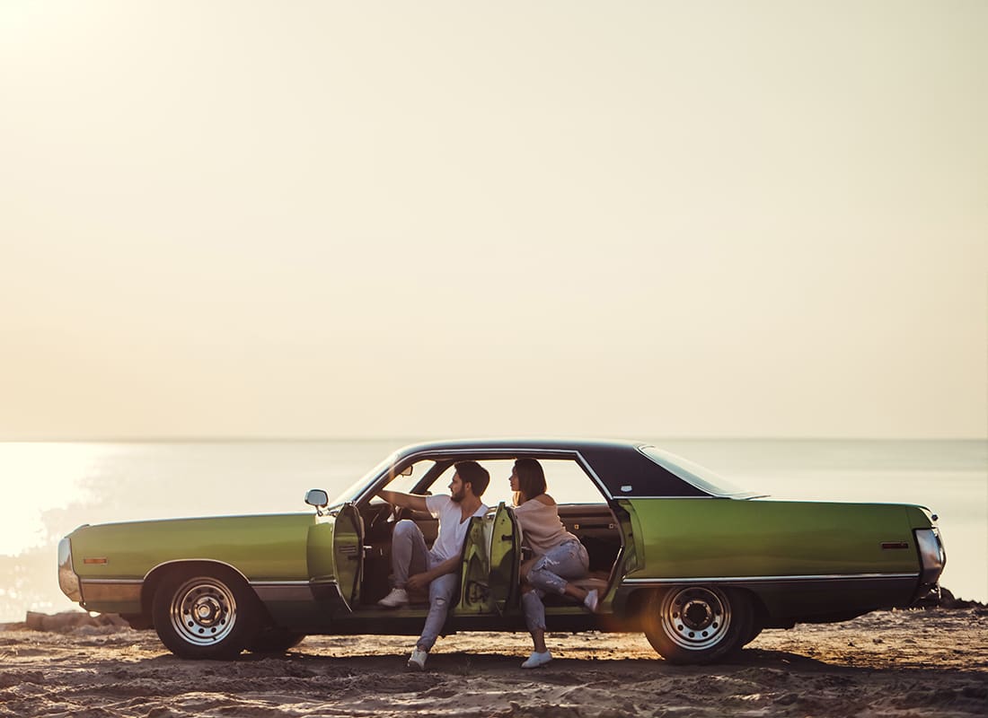 Personal Insurance - Couple With Retro Car WIth a Beautiful Ocean in the Background